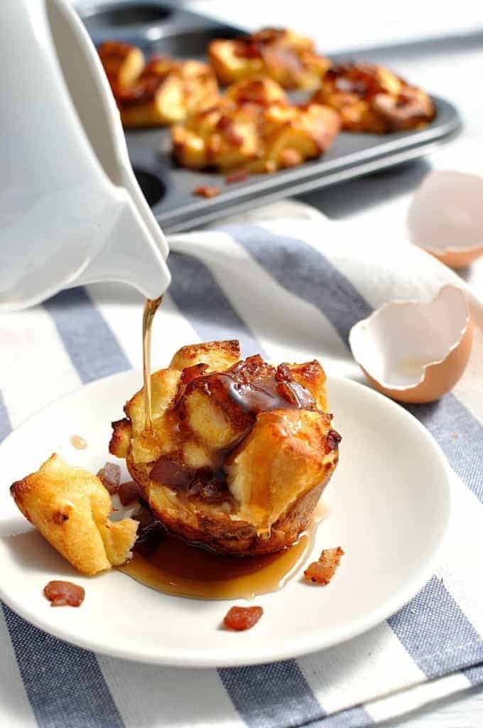 Maple syrup being poured over bacon French toast muffins