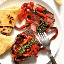 Steak with Pesto and chargrilled capsicum on a white plate, ready to be eaten.