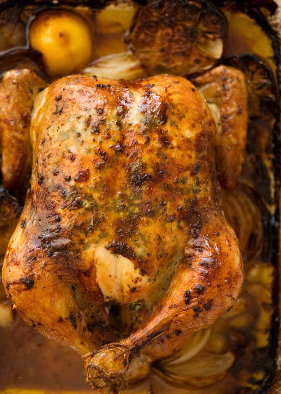 Overhead photo of Roast Chicken in a roasting pan with garlic-herb-lemom butter, fresh out of the oven