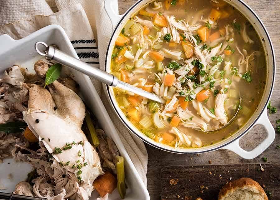 Pot of Chicken Noodle Soup from scratch with boiled chicken beside it