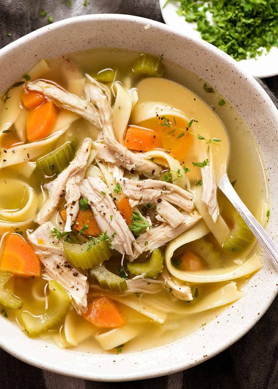 Overhead photo of Chicken Noodle Soup from scratch (whole chicken) in a bowl, ready to be eaten 