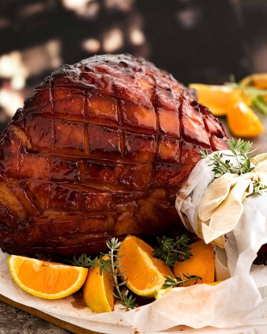 Maple Ham Glaze - glazed ham om a platter, ready to be carved. The most incredible baked ham ever!