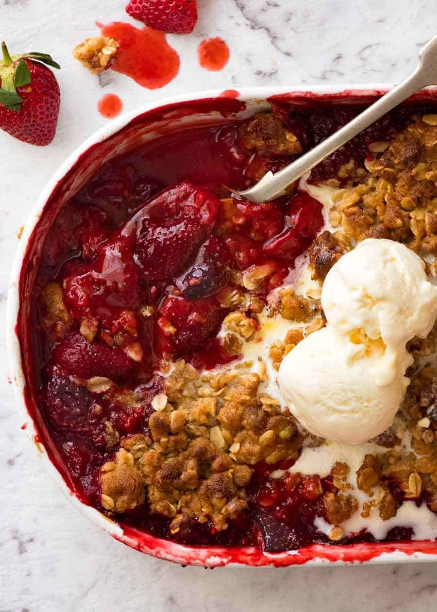 Close up of Strawberry Crumble in a white pudding dish, fresh out of the oven.