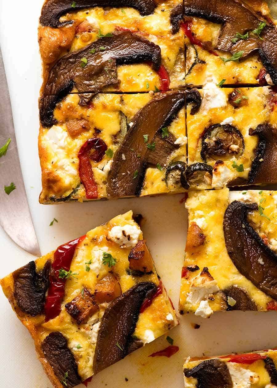 Overhead photo of Baked Frittata with Roasted Vegetables cut into slices, fresh out of the oven